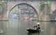 China: Boatman in front of the mist covered Hong Qiao Bridge, Fenghuang's famed covered bridge, Fenghuang, Hunan Province